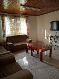 een woonkamer met een bank en een salontafel bij Topsta Apartment in Kisii