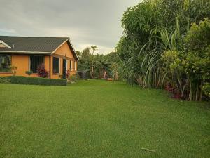 een huis met een tuin met groen gras bij Topsta Apartment in Kisii