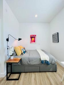 a bed sitting in a room with a table at Brand New Luxury Fully Furnished Studio Suite in Oakland