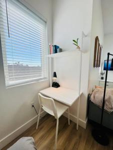 a small white desk in a room with a window at Brand New Luxury Fully Furnished Studio Suite in Oakland
