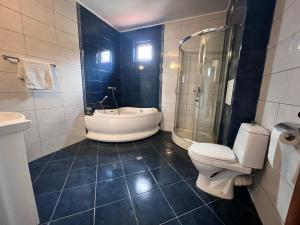 La salle de bains est pourvue d'une baignoire, de toilettes et d'un lavabo. dans l'établissement Къща Каменар, à Pomorie