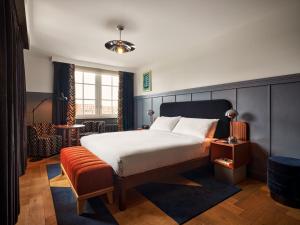 a hotel room with a bed and a chair at The Hoxton, Lloyd Amsterdam - Eastern Docklands in Amsterdam