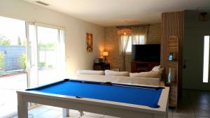 a living room with a couch and a pool table at Chambre dans maison, près de la mer, de l'Espagne, des Montagnes in Pézilla-la-Rivière