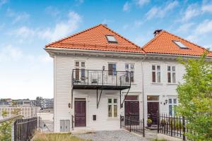 Biały dom z pomarańczowym dachem w obiekcie Contemporary city-apartement with views of the dock! w Bergen