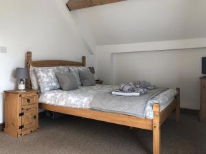 a bedroom with a wooden bed and a night stand at The Pig Sty in Barlow