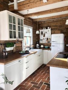 eine Küche mit weißen Schränken und Holzwänden in der Unterkunft Dom z Bieszczad na Kaszubach - całoroczny dom z balią ogrodową in Kowalewo