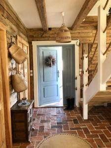 korytarz z niebieskimi drzwiami i ceglaną podłogą w obiekcie Dom z Bieszczad na Kaszubach - całoroczny dom z balią ogrodową w mieście Kowalewo