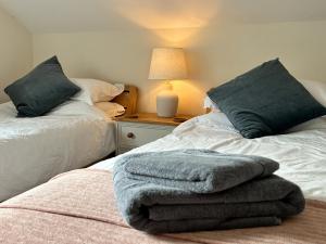 two beds sitting next to each other in a bedroom at Chestnut Cottage in Wookey