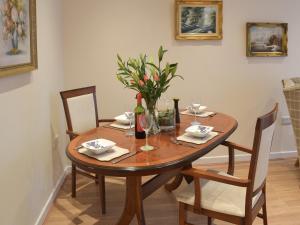 una mesa de madera con una botella de vino y flores. en Red House en Torquay