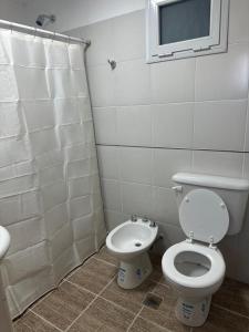 a bathroom with a toilet and a sink and a window at Monoambiente céntrico in Comodoro Rivadavia