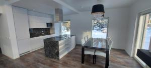 a dining room with a glass table and a kitchen at VILLA MARIA in Turku