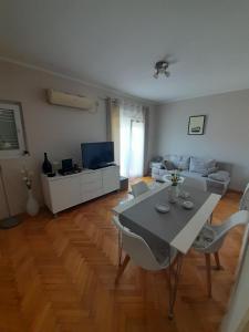 una sala de estar blanca con mesa y sillas en Jasna Herceg Novi en Herceg-Novi
