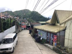uma carrinha branca estacionada numa rua ao lado de um edifício em Baguio Classic Cozy Home em Baguio