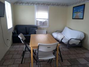 a living room with a table and chairs and a couch at Four Winds Motel in Seaside Heights