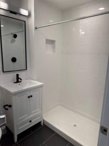 a white bathroom with a sink and a mirror at Fully-Stocked Studio Suite in Oakland