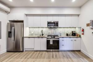 奧克蘭的住宿－Fully-Stocked Studio Suite，厨房配有白色橱柜和不锈钢用具