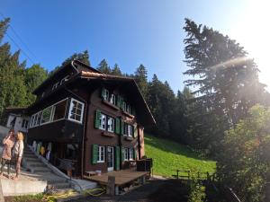 Dom z ludźmi stojącymi przed nim w obiekcie Chalet Sonnenheim mit atemberaubender Aussicht w mieście Adelboden