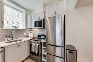 a kitchen with white cabinets and a stainless steel refrigerator at Entire Furnished Luxury Apt in Lake Merritt in Oakland