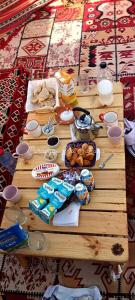 a wooden table with food and drinks on it at Private Camp25km-from DOUZ in Douz