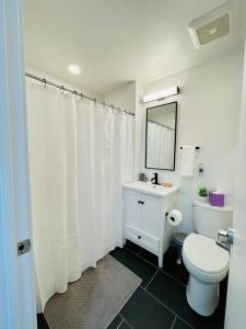 a bathroom with a toilet and a sink and a mirror at Fully-Stocked Studio Suite Near Downtown Oakland in Oakland