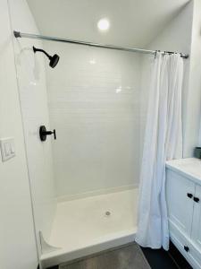 a bathroom with a shower with a white shower curtain at Fully-Stocked Studio Suite Near Downtown Oakland in Oakland