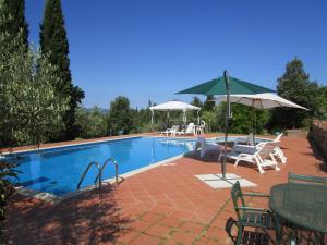 una piscina con sedie e ombrelloni accanto ad essa di Casale del Vacanziere a Certaldo