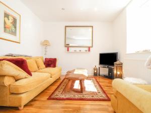 a living room with a couch and a table at Dragonfly Cottage in St Austell