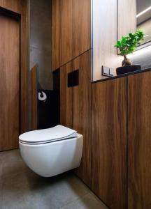a bathroom with a white toilet and a plant at Feel in forest in Vilnius