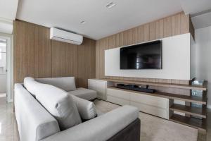 フロリアノポリスにあるLuxury at the beach!Wi-Fi500Mpbsのソファと薄型テレビのあるリビングルーム