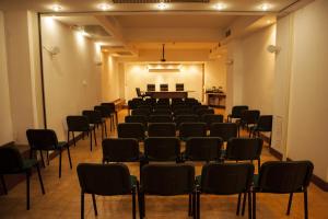 a room with rows of chairs and a piano at Hotel Piccada in Palau