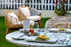 une table avec des assiettes de nourriture au-dessus dans l'établissement BCascais Boutique House by APT IIN, à Cascais