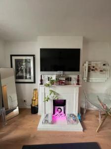 ein Wohnzimmer mit einem Flachbild-TV und einem Wohnzimmer in der Unterkunft Cosy & Chic 1BD Flat - 6 Minutes to Notting Hill! in London