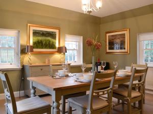 a dining room with a wooden table and chairs at Gardeners Cottage in Montrose