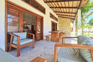 a living room with chairs and a table at Chalés em Jericoacoara por Carpediem in Jijoca de Jericoacoara
