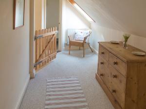 a attic room with a dresser and a chair at Old Dairy - Ukc3169 in Walpole