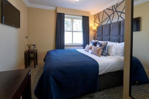 a hotel room with a large bed and a window at Mandolay Hotel Guildford in Guildford
