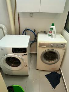 a laundry room with a washer and a washing machine at The Corinthan in Kuala Lumpur