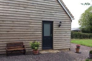 Country Studio Apartment في Charlton: منزل فيه باب اسود ومقعد +7 صور