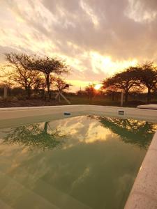 a reflection of the sunset in a swimming pool at "AGUAPÉ" Alojamiento rural con PILETA in Chajarí