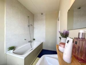 La salle de bains est pourvue d'une baignoire et d'un lavabo. dans l'établissement Holiday Home Sungarden, à Middelkerke
