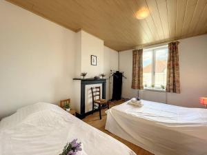 - une chambre avec 2 lits, une cheminée et une fenêtre dans l'établissement Holiday Home Sungarden, à Middelkerke