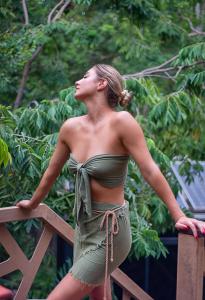 a woman in a green dress standing on a fence at Bufo Alvarius in Tulum