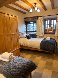 a bedroom with two beds and a window at Swallows Barn in Penrith