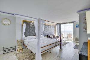 um quarto com cama de dossel e varanda em Cozy Florida Getaway with Pool Access and Ocean Views! em Daytona Beach