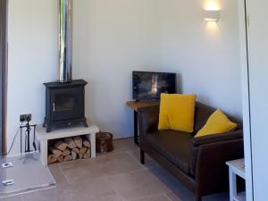 a living room with a couch and a stove at Wrens Nest in Chippenham