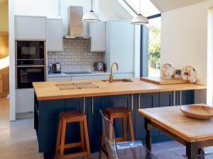 a kitchen with white cabinets and a wooden counter top at Wrens Nest in Chippenham