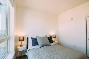 1 dormitorio blanco con 1 cama y 2 lámparas en Luxury 1 Bedroom unit in West Oakland en Oakland