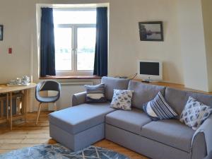 a living room with a gray couch with pillows at The Mill The Mill House in Ludham