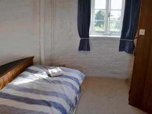 a bedroom with a bed and a window at The Mill The Mill House in Ludham