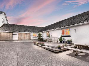 a patio of a house with a bench and tables at Manor Farm in Coffinswell